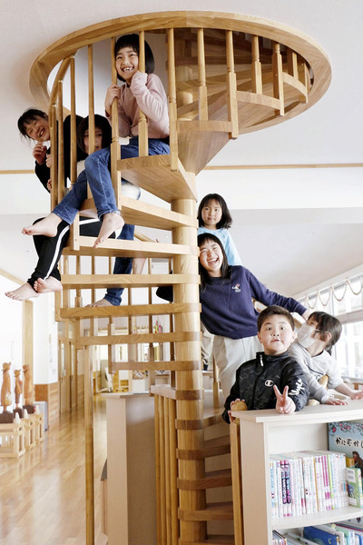 いいたて希望の里学園内にある木製のらせん階段で、無邪気な笑顔を見せる子どもたち。子どもたちの存在は村が未来へと歩む原動力だ（飯舘村提供）