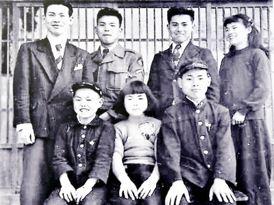 自分の原点として大切にしている７人きょうだいの写真。末っ子の私（前列左）は家族みんなにかわいがってもらった