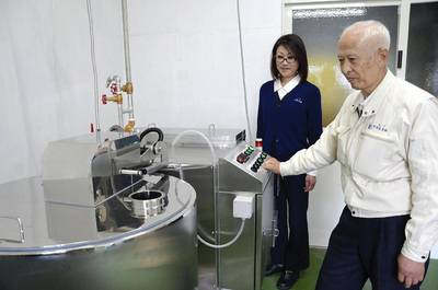 工場内に設置したチーズ製造機を点検する私（右）。応援を得て首都圏との取引の継続もかなった