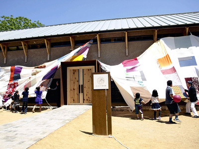 開館日は古布や仕切り布を縫い合わせた大風呂敷で除幕式を行った