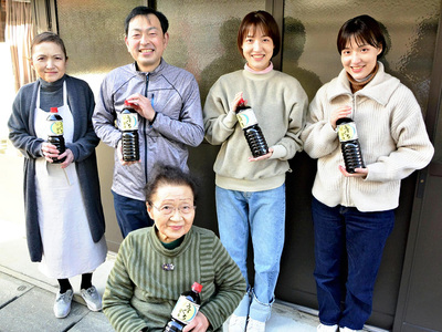 義母の京子（前列）、妻の文江（後列左）、双子の娘ゆきの（後列右から２人目）、絢華（後列右）と店の前に立つ私。家族５人でのれんを守っている