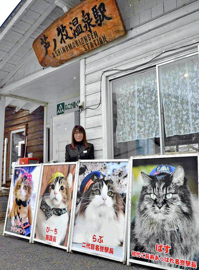 芦ノ牧温泉駅の駅舎の前に立つ私。駅舎の前には、ネコ従業員４匹の写真を飾っている