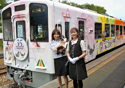 お披露目されたラッピング車両の前で記念撮影する私とらぶ（左）。ファンのおかげで映画化とラッピング車両が実現した。右は映画でさくらを演じた声優の明坂聡美さん