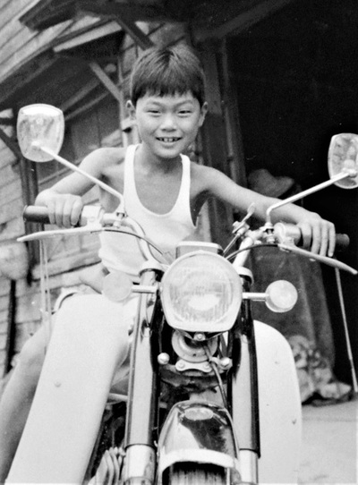 バイクにまたがりポーズをとる小学生時代の私。正直どんな状況で撮影した写真なのか不明だが、当時はいたずらっ子だったらしい