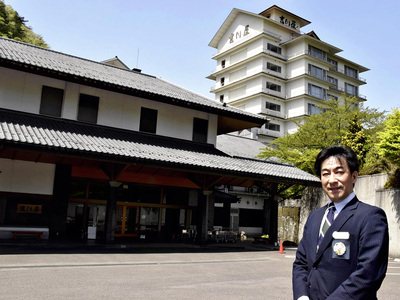 吉川屋の前に立つ私。創業１８３年の老舗旅館をどう守り、成長させていくか。与えられた使命に全力で向き合いたい