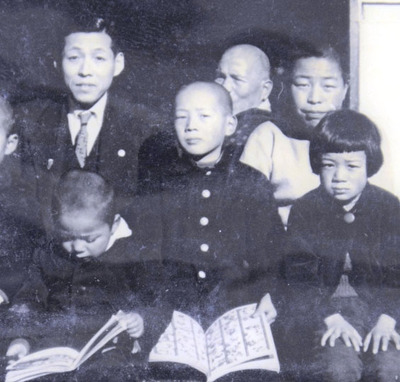 小学生の頃に親戚たちと撮影した集合写真。中央は私、左上が父