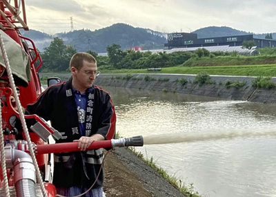 消防団の訓練に参加する私。当初は入団を断っていたが、今は町を守るために一生懸命取り組んでいる