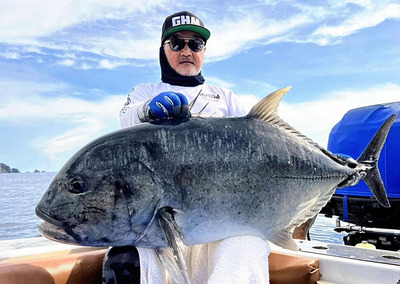 釣り上げた３０キロの大型魚ロウニンアジを持ち上げる私。年に１度の海外での釣りでリフレッシュができている＝今年３月、インドネシア・バリ島