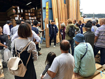 押田製材所のイベントで競りをする私（奥中央）。人も材木もみんな違っているのが当たり前で、良いところを伸ばしていくことが大切だ