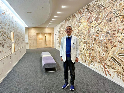 こどもの心センターに続く１４メートルの廊下。背景はあさかホスピタルグループ２７カ所の土を使って浅井裕介氏と皆で描いたウォールアート「大地の泉とひかりの木」