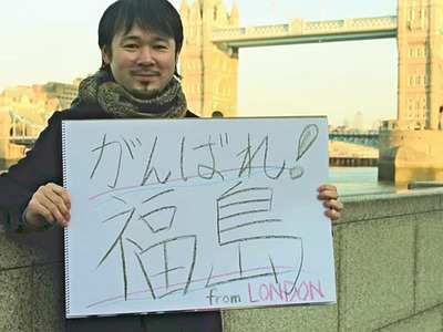 タワーブリッジの前で「がんばれ！福島」と書いた紙を掲げる私。居ても立ってもいられず、地元福島に交流サイト（ＳＮＳ）を通じて応援メッセージを届けた