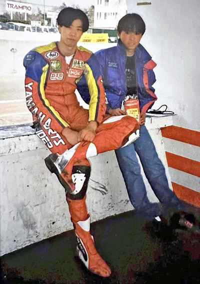 レーシングスーツを着て仲間と並ぶ私（左）。後輩の事故死をきっかけにプロの夢を断念し、新たな道を模索し始めた