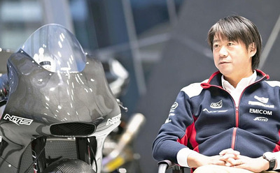 現在の社屋で車体を手がけたバイクを見つめる私。加工業の世界チャンピオンを目標に、これからも突き進みたい