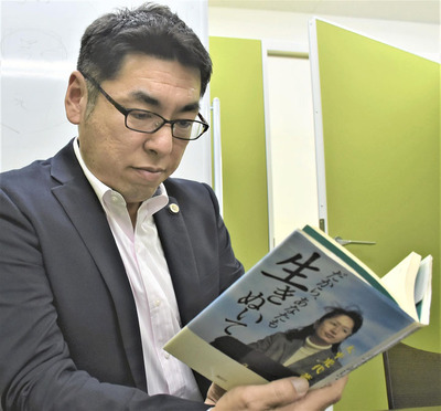 大平さんの著書「だから、あなたも生きぬいて」を読む僕。聖典として僕の法律事務所の一角に飾っている