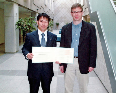 大学院博士課程を修了した際の写真。右は指導教官のＡｌｅｘａｎｄｅｒ　Ｇ　Ｂｅｌｙａｅｖ先生。博士課程の３年間は土日もなく、ひたすらコンピュータに張り付く日々だった
