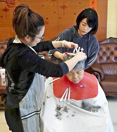 老人ホームや介護施設で散髪やマッサージのお手伝いをする私（奥）。言葉や文化の壁に苦労しながらも、ボランティア活動は台湾に渡った頃から続けていた