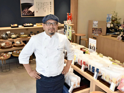 「ぬか茂菓子店」の店内に立つ私。現在の店名は、２代目の茂吉が自分の名から一文字取り、創業当初の「糠沢菓子店」とかけ合わせて誕生した