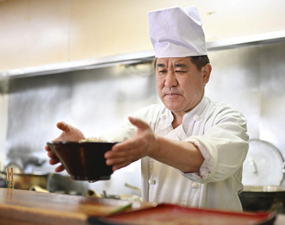 思いを込めたラーメンをカウンターに出す大塚さん（矢内靖史撮影）