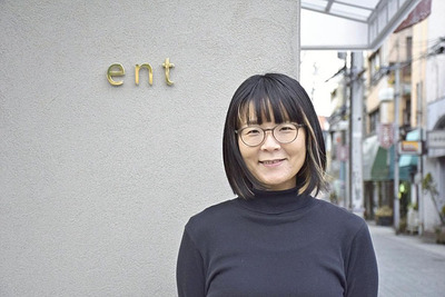 転入者がいつでも立ち寄れるようにと運営するショップ「ｅｎｔ」の前に立つ私。転入者が地域や社会とつながり、自分らしく暮らせるように。そんな願いを込めて支援活動を行っている