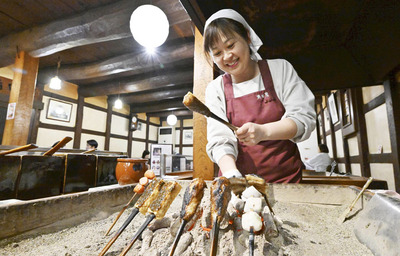 囲炉裏で田楽を焼く満田加津美さん。みそ蔵を改装した店内には香ばしい香りが広がる