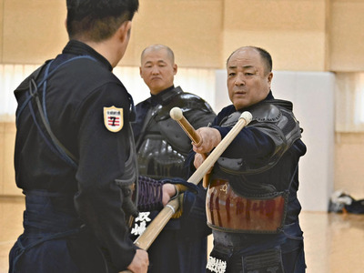 選手を指導する佐藤さん（右）