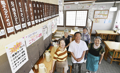 長年ともに働く従業員と笑顔で客を迎える隆夫さん（手前中央）とヒデ子さん（同左）
