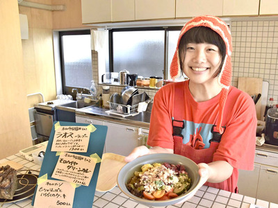 地元の野菜などを使った「多国籍丼」を手にする堀さん