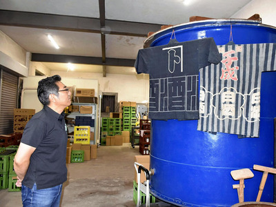 酒造タンクを見つめ、経営を案じる斎藤社長。酒造好適米の価格高騰が蔵元の経営に重くのしかかっている＝二本松市・檜物屋酒造店