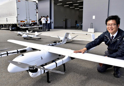 出場するドローンを前に「今後起きる災害の被害やリスクを減らしたい」と語る金田さん。後ろは撮影や通信の中継を行う子機ドローン