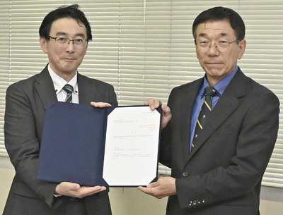 須田市長（右）から諮問書を受けた樋口委員長