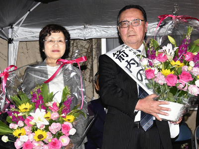 無投票で再選し、花束を受ける箭内氏（右）と妻京子さん