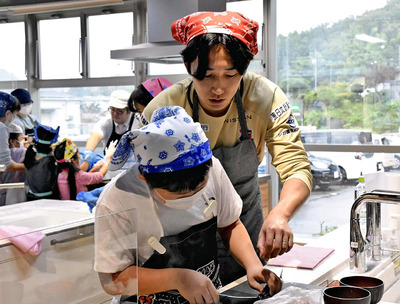 参加者と交流しながら調理するＤＦ遠藤選手（右）