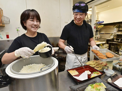 調理場で料理を盛り付ける康仁さん（右）と妻直美さん。「信用を第一にこれからも末永く店を続けていけたら幸せ」と笑顔で話す