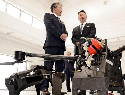 水素燃料のドローン(手前)について吉田町長に説明する五十嵐社長(右)