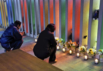 慰霊館でモニュメントに手を合わせる当時校長だった岩橋さん（左）と靖さんの妻＝２０１１年１０月、オーストリア・カプルン（涌井さん提供）