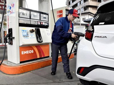 車に給油する従業員。県内でも徐々に店頭価格が下がる見通しだ＝１３日午後、福島市