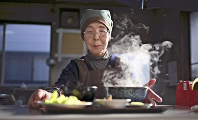 うどんセットを運ぶ佐智子さん。早朝から仕込んだこだわりの手打ちうどんから湯気が立ち上る