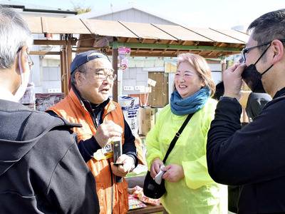 震災から１５年ぶりに十日市祭に出店し、店先で来場者と思い出話に花を咲かせる優蔵さん（中央左）と裕子さん（同右）。出店には震災前に使っていた屋台を使用した＝浪江町