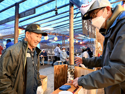 茶屋に訪れた来場者と会話を弾ませる阿部さん（左）＝飯舘村・山津見神社境内