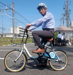 　水素を燃料にするアシスト自転車に試乗するトヨタ紡織の社員＝１４日午後、愛知県刈谷市