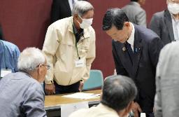 　５月、発言を遮った問題を巡り「水俣病被害者・支援者連絡会」の山下善寛代表代行（左端）に頭を下げる伊藤環境相＝熊本県水俣市