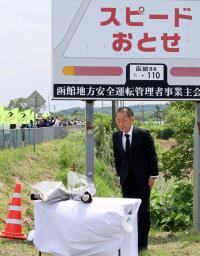 　事故現場で花を手向ける北海道警幹部＝１８日午前、北海道八雲町