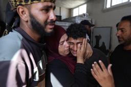 　パレスチナ自治区ガザ中部デールバラハで、イスラエル軍の攻撃で死亡した親族を悼む人々＝１９日（ＡＰ＝共同）
