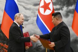 　１９日、北朝鮮・平壌での調印式で、文書を交換する金正恩朝鮮労働党総書記（右）とロシアのプーチン大統領（ＡＰ＝共同）