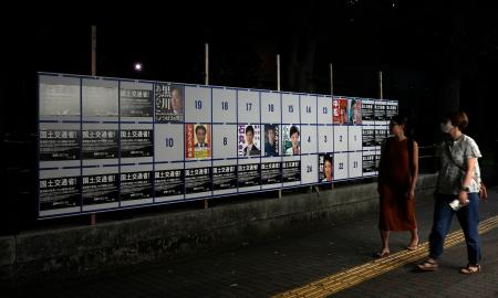 　東京都知事選で、半分ほどの枠が同一のポスター（左右と下）で埋め尽くされた掲示板＝２０日夜、東京・霞が関