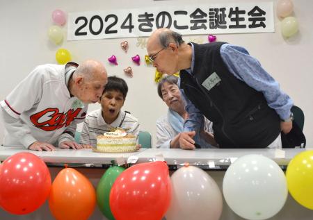 　「きのこ会」の誕生会で、ケーキのろうそくの火を吹き消す原爆小頭症の被爆者＝２２日午前、広島市