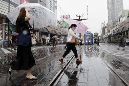 　雨が降る鹿児島市内で、傘を差して歩く人たち＝２０日