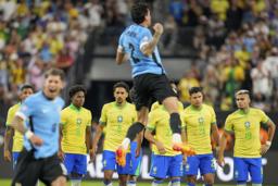 　サッカーの南米選手権、勝利を喜ぶウルグアイの選手（手前）と肩を落とすブラジルの選手たち＝６日、ラスベガス（ＡＰ＝共同）