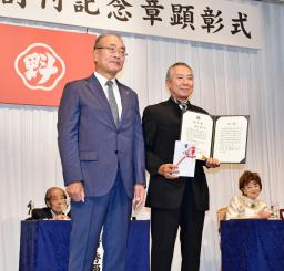 　秋田魁新報社の佐川博之社長（左）から創刊記念章を受けた柳葉敏郎さん＝８日、秋田市