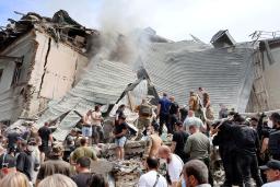 　８日、ロシアの攻撃を受け一部建物が崩壊したウクライナ・キーウの小児病院。多くの人々が救助活動に当たった（共同）